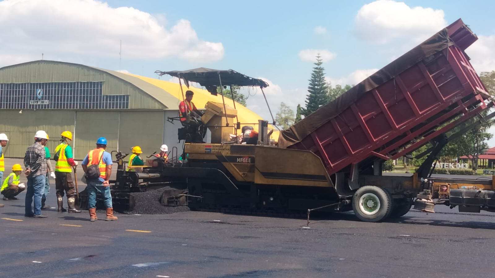 Penuangan Material Aspal ke Mesin Penghampar